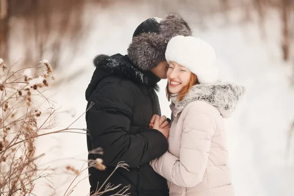 Pasear con el perro en invierno. pareja amorosa está caminando en la nieve — Foto de Stock