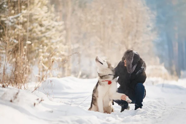 Procházky se psem v zimě. milující pár se chůze ve sněhu — Stock fotografie
