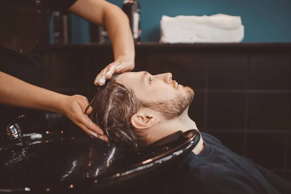 Haarstylist wassen van het haar van de klant in de kapper — Stockfoto