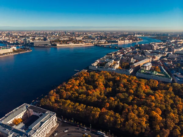 Podzimní městské krajině, Park s Golden stinnými stromy, lodní tmavě modrá řeka Něva, mosty z Petrohradu, pohled shora. — Stock fotografie