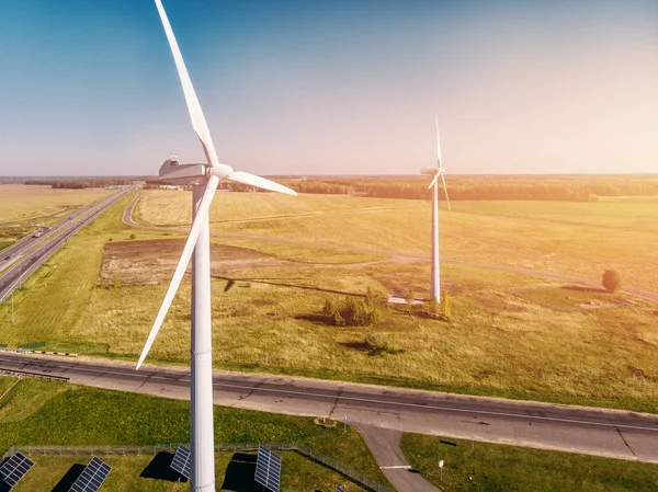 wind turbine close-up on background of forest belt and intersecting roads