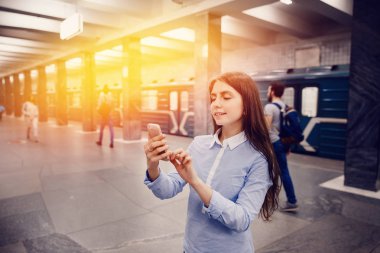 Metroda telefonda konuşuyor ve gülümseyen genç kız Turizm