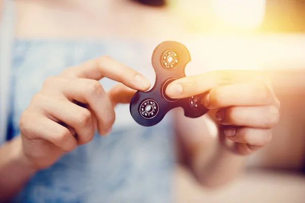 Girl to play with Fidget Spinner in his hands, the concept of relieving stress