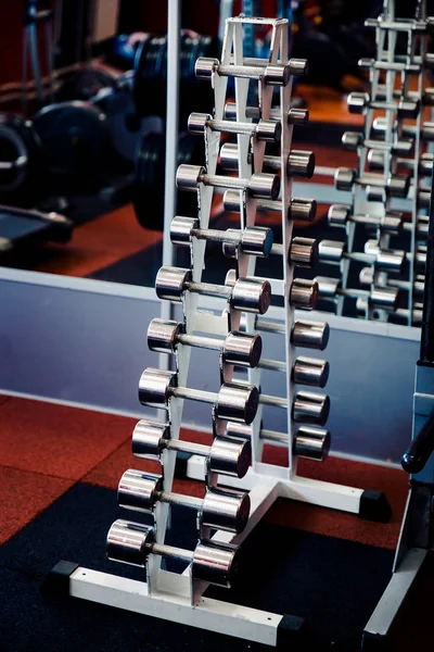 Üst üste bir stand dumbbells düzenlendiği. — Stok fotoğraf