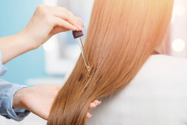 Mujer Maestra Aplicando Mascarilla Aceite Las Puntas Del Cabello Salón —  Fotos de Stock