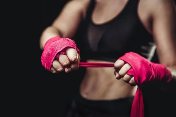Femme enveloppe ses poings de bandages roses pour gants de boxe — Photo