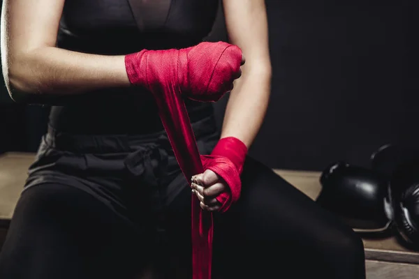 Frau wickelt ihre Fäuste in rosa Bandagen für Boxhandschuhe — Stockfoto
