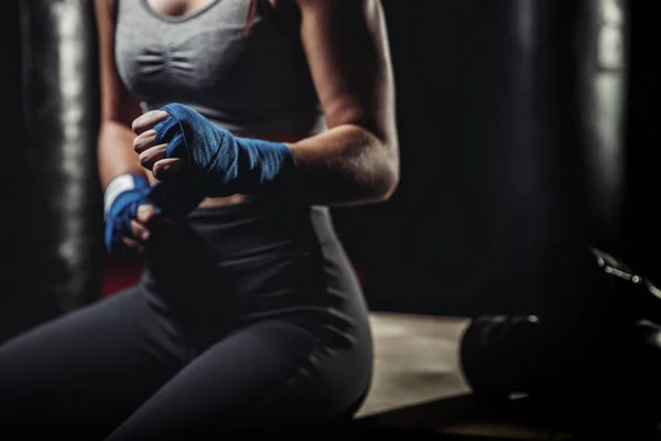 Mujer envuelve sus puños en vendas rosas para guantes de boxeo — Foto de Stock