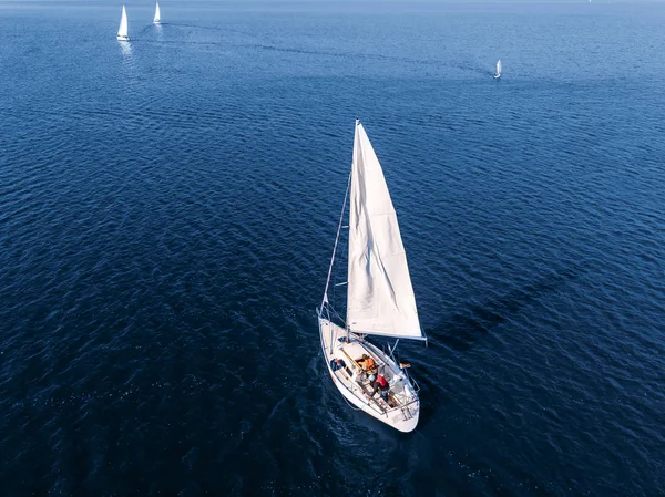 Antenowe drone drogich jacht z biały żagiel na błękitne wody morza — Zdjęcie stockowe