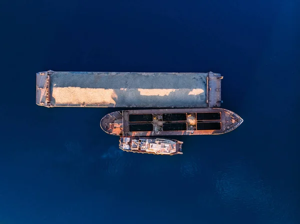 Schiffsschlepper schiebt Lastkahn mit Schüttgut aus Schuttsand in blauem Wasser des Meeresflusses. — Stockfoto