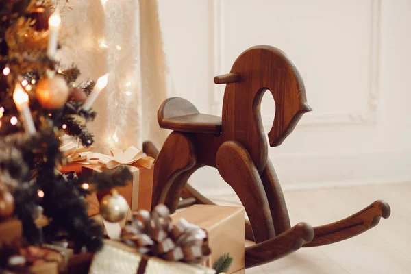 Jouet de cheval en bois sous l'arbre de Noël entouré de cadeaux — Photo