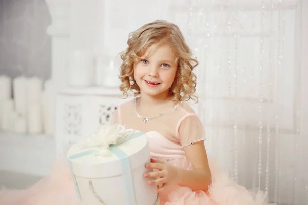 Маленька усміхнена дівчинка з різдвяною новорічною подарунковою коробкою . — стокове фото