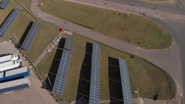 Комбінована електрогенерація сонячних панелей і вітряних млинів знаходиться на дорозі, забезпечує АЗС і теплицю. Вид зверху Повітряний дрон — стокове відео
