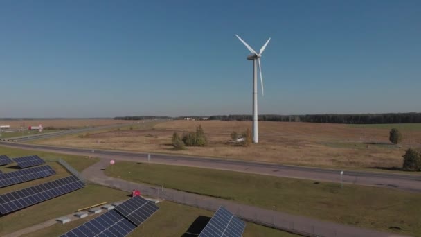 Painéis solares e moinhos de vento combinados de geração de energia estão na estrada, fornecem posto de gasolina e estufa. Vista superior — Vídeo de Stock