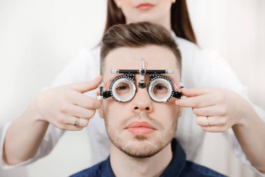 Özel oftalmik gözlüklü genç kadın doktor tutar seçimi lens için moda esmer adam portresi