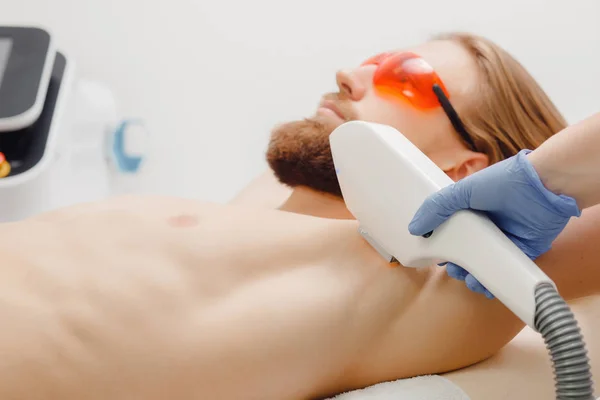 Male depilation laser hair removal procedure treatment in salon.
