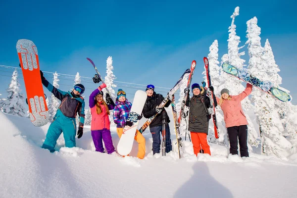 Grupo de gente alegre con esquís y tablas de snowboard juegan —  Fotos de Stock