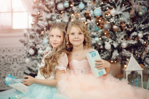 快乐的孩子姐姐打开魔术礼物家附近的树在礼服。圣诞快乐. — 图库照片