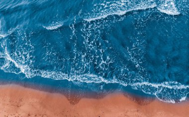 Sandy beach mavi deniz suyu için arka plan doğa beyaz köpük ile.