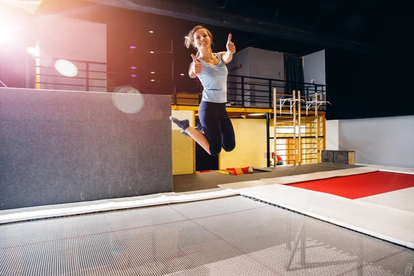 Giovane donna sportivo fitness jumping su trampolino club — Foto Stock