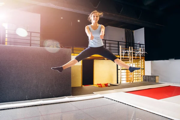 Jeune femme sportif fitness saut sur trampoline club — Photo