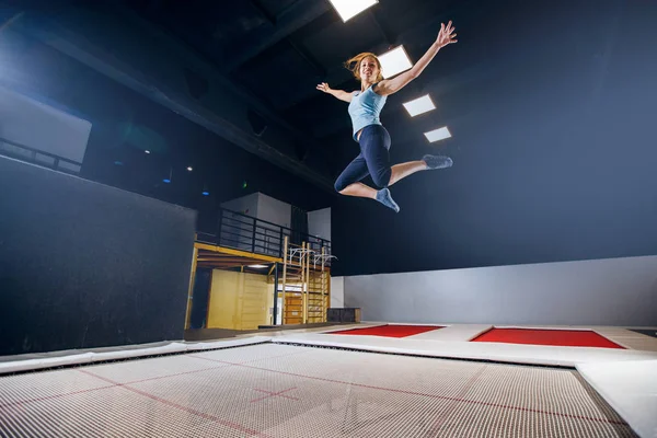 Giovane donna sportivo fitness jumping su trampolino club — Foto Stock