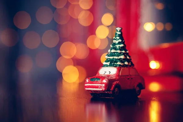 Christmas tree on toy car, bokeh background. — Stock Photo, Image