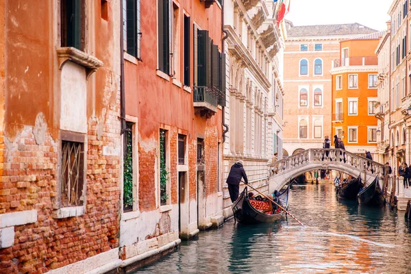 Gondolier membawa turis di sepanjang kanal — Stok Foto