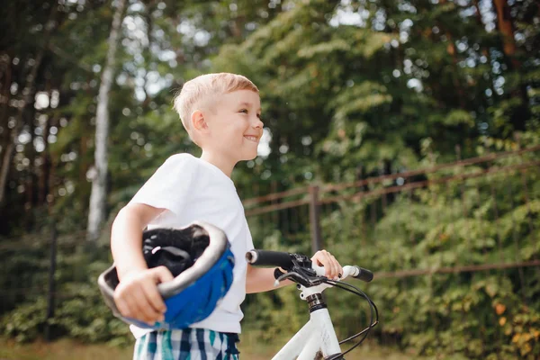 Rapaz de capacete a andar de bicicleta no parque. Divertir-se dia de verão . — Fotografia de Stock