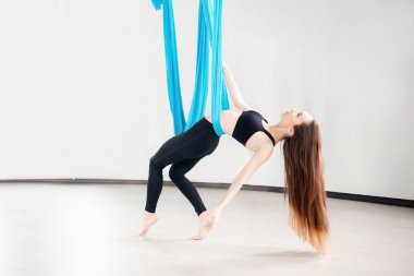 Beyaz stüdyoda yerçekimsiz hava yogası yapan genç bir kadın. Meditasyonu kabul et