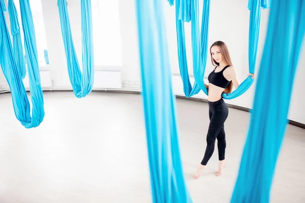 Yoga de mouche aérienne dans le gymnase blanc. Jeunes belles femmes pratiquant des pilates étirant dans l'hamac bleu — Photo