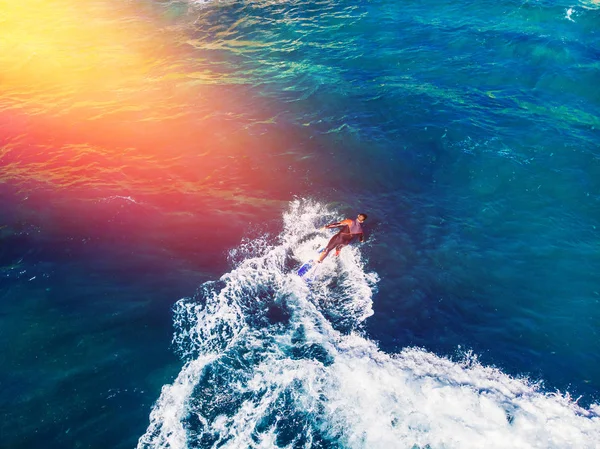 Surfer rows up to catch crest of wave in blue ocean. Concept surfing. Top view — Stock Photo, Image