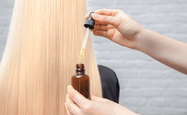Procédure de coiffeur maître traitement des cheveux à l'huile pour femme. Concept spa salon. — Photo