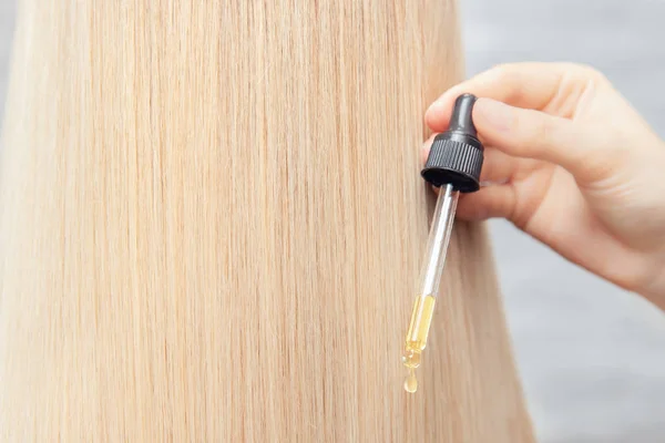 A baixa de close-up de restauração de óleo e cabelo de recuperação é aplicada a bulbos dianteiros. Conceito salão de spa cabeleireiro — Fotografia de Stock