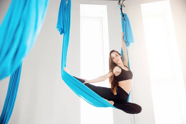 Terbang udara yoga wanita cantik pesenam di hammock biru — Stok Foto