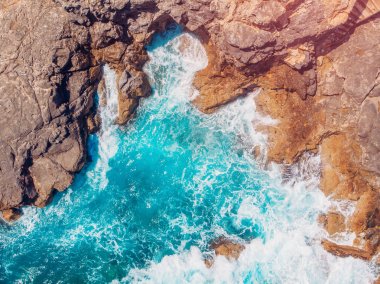 Üst görünüm plaj ve kayalar üzerinde dayak dalgaları ile Azure mavi deniz. Havadan fotoğraf.