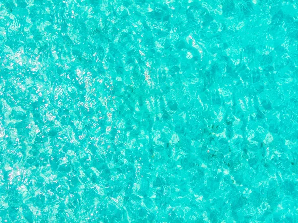 背景蓝色绿松石海, 透明的水与波浪的纹理, 阳光明媚的日子。鸟瞰 — 图库照片