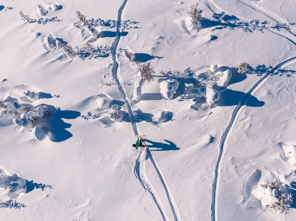 Atleta snowboarder paseos fuera de pista snowboard limpio de nieve, intacto en el bosque en la pendiente. Vista superior aérea — Foto de Stock