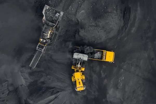 Open pit mine, coal loading in trucks, transportation and logistics, top view aerial drone