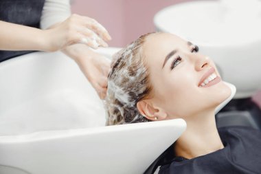 Güzel sarışın kadın güzellik salonunda saç yıkama almak. Konsept kafa masajı