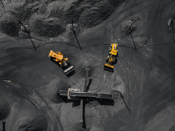 Open pit mine, coal loading in trucks, transportation and logistics, top view aerial. Concept industrial