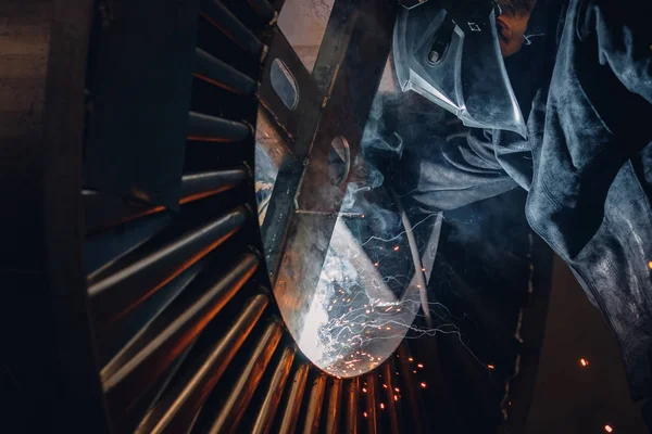 Professional welder in protective uniform with face mask, sparks fly apart, welding with an electrode — Stock Photo, Image