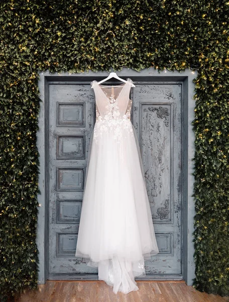 新娘的白色婚纱挂在门的背景，博霍和质朴的风格 — 图库照片