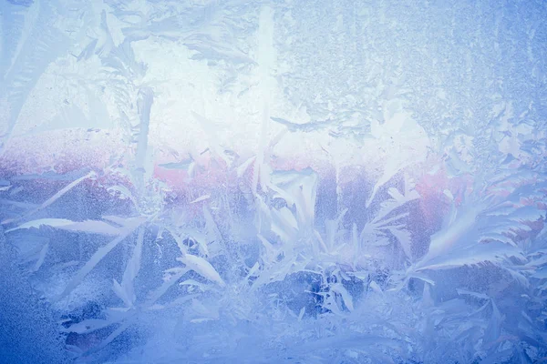 Frost drawing on window glass, snowflake ornament after anomaly ice cold