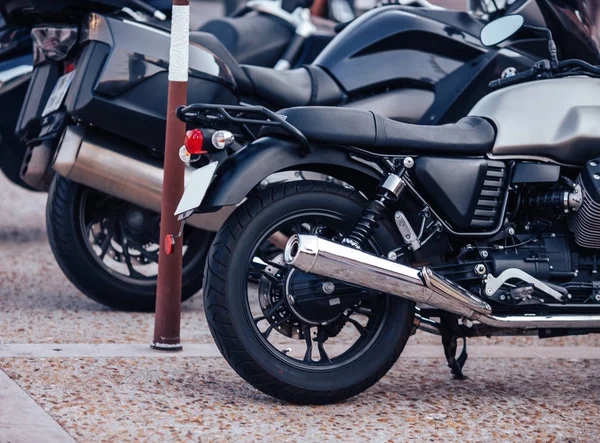 Rent row black scooter motorbikes standing in parking lot