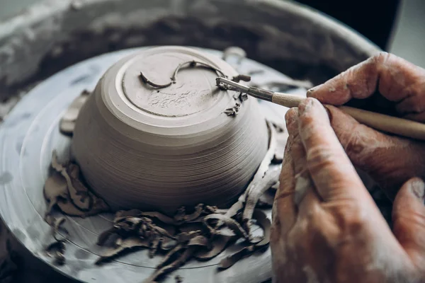 Turkish master paints and cuts clay plate patterns. Concept craft