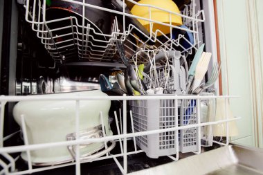 Yıkama için ayarlanmış kirli bulaşıkları ile açık bulaşık makinesi. Konsept su tasarrufu