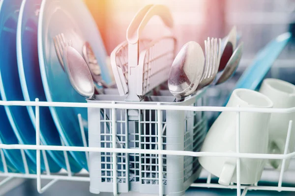 Máquina de lavar louça aberta com pratos de brilho limpo e garfos, colheres, talheres. Conceito economia de água — Fotografia de Stock