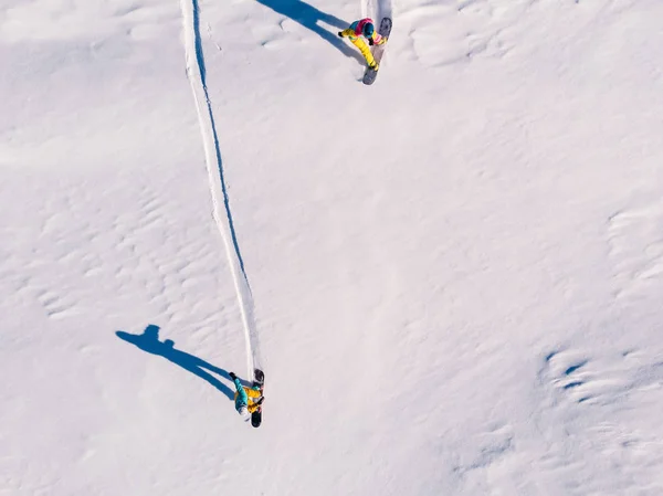 アスリートのスノーボーダーは、斜面に森の中で手付かずのきれいなスノースノーボードをピストます。上空のトップビュー — ストック写真
