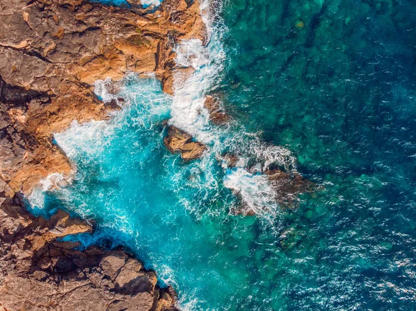 Vista superior Mar azul azulado con olas golpeando en la playa y rocas. Foto aérea . — Foto de Stock